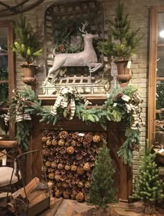 a fireplace decorated for christmas with pine cones and greenery