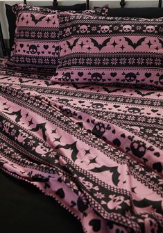 a bed with pink and black sheets on it