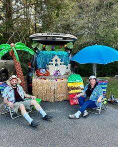 two people sitting in lawn chairs next to an open golf cart with decorations on it