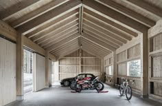 a motorcycle parked in a garage next to a car and a bike on the floor