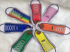 four pairs of colorful sneakers with white laces on them are arranged in a circle