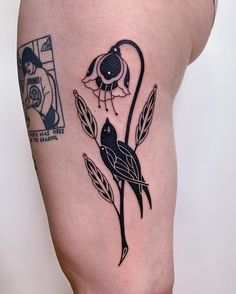 a tattoo on the leg of a woman with a bird and flower in its beak