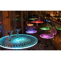 an illuminated table and chairs on top of a building