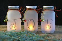 three jars with lights in them sitting on a table