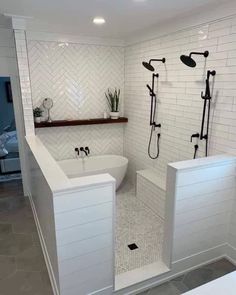 a bathroom with white tile and black fixtures in the bathtub, shower head, and toilet seat