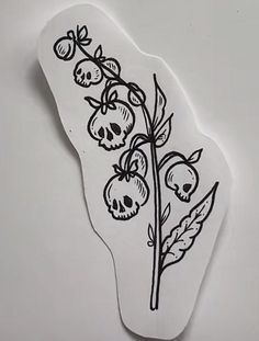 a piece of paper with black ink on it that has flowers and skulls drawn on it