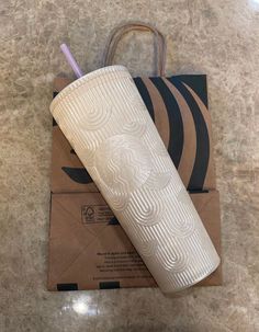 a white cup sitting on top of an envelope