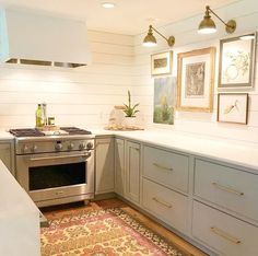 a kitchen with an oven, stove and pictures on the wall