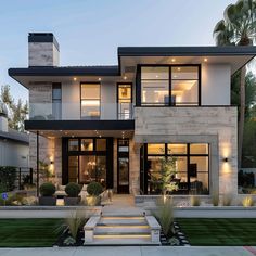 a modern house with stairs leading up to the front door