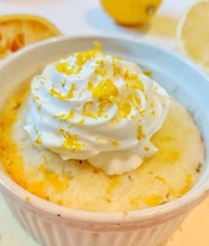 lemon mug cake with whipped cream in a white bowl on a yellow background and the caption reads, that tastes like sunshine