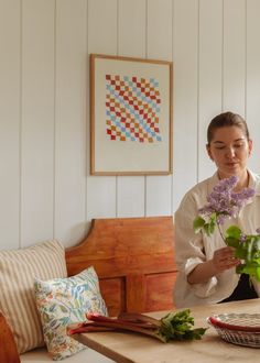 a woman is arranging flowers on a table