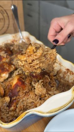 a person scooping food out of a casserole dish