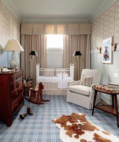 a baby's room with an animal rug, rocking chair and crib in the corner