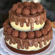 a triple layer cake with chocolate frosting and raspberries on top