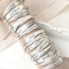 a stack of silver bracelets sitting on top of a table