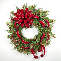 a christmas wreath with red bows and greenery on the front is displayed against a white background