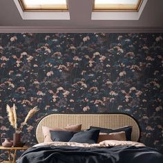 a bedroom with floral wallpaper and a bed in front of a skylight window