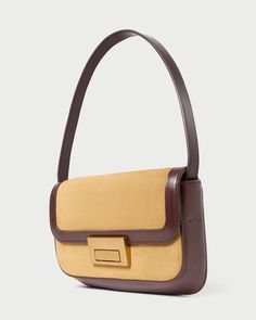 Shoulder baguette bag in hazel tan suede with espresso brown vachetta leather trim. Features slim tonal handles, a push lock closure, full lining, interior zippered pocket, and exterior slip pocket. Timeless Brown Shoulder Bag For Evening, Brown Suede Shoulder Bag For Work, Elegant Baguette Satchel Bag With Leather Handles, Elegant Beige Baguette Bag With Leather Handles, Timeless Brown Evening Bag, Timeless Brown Satchel Flap Bag, Brown Baguette Bag With Detachable Handle For Travel, Evening Shoulder Bag With Leather Trim And Double Handle, Travel Brown Baguette Bag With Detachable Handle