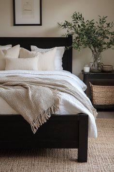 a bed with white linens and pillows in a small room next to a potted plant