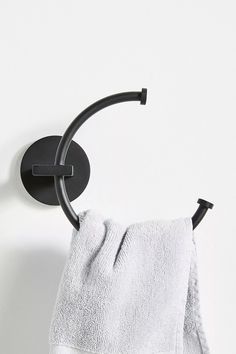 a towel is hanging on the wall next to a black hook and two white towels