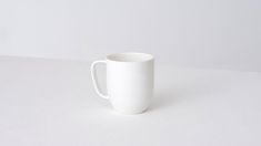 a white cup sitting on top of a table