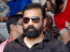 a man with sunglasses and beard standing in front of people