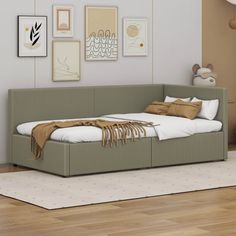 a day bed sitting on top of a hard wood floor next to a white rug