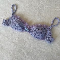 a crocheted bralet laying on top of a bed