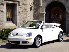 a white convertible car parked in front of a building