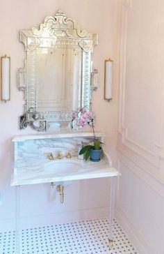 a bathroom sink sitting under a mirror next to a wall mounted faucet