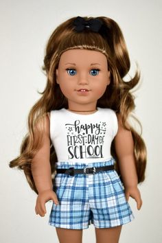 a close up of a doll wearing a shirt and shorts with the words happy first day of school on it