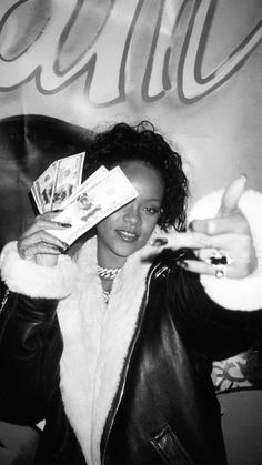 a woman in a leather jacket holding up cards