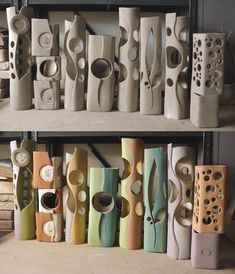 there are many different types of vases on the shelves in this room and one is made out of clay