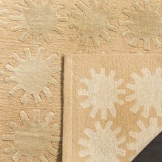 two pieces of rugs with snowflakes on them, one black and the other beige