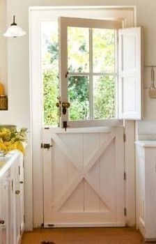 a white kitchen with an open barn door