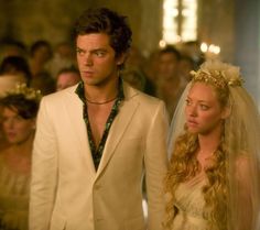 a man and woman dressed in white standing next to each other at a wedding ceremony