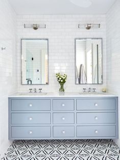 a bathroom with two sinks and mirrors on the wall next to each other in front of a tiled floor