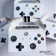 the front and side of a white box with black buttons on it, surrounded by other game controllers