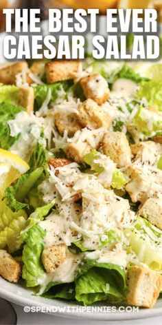 the best ever caesar salad with lemon wedges and parmesan cheese on top