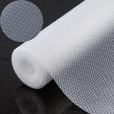 a roll of white fabric sitting on top of a black table next to two circles