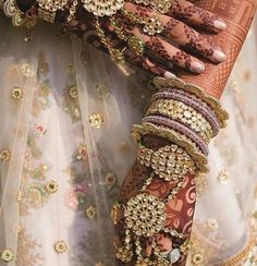 a close up of a woman's hands with bracelets and jewelry on her arm