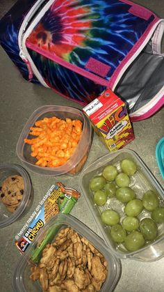 the lunch box is filled with grapes, carrots, crackers and other snacks