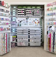 an organized closet with lots of craft supplies and storage bins on the shelves in front of it