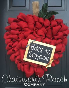 a back to school wreath hanging on the front door with a chalkboard sign attached