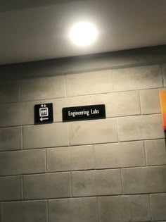 two signs on the wall that say engineering labs and an electrical light is above them