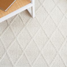 a white coffee table sitting on top of a rug next to a chair and desk