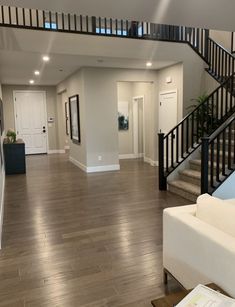 a living room filled with furniture and a stair case in front of a white door