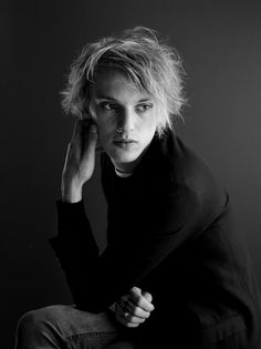 a black and white photo of a woman with blonde hair wearing a turtle neck sweater