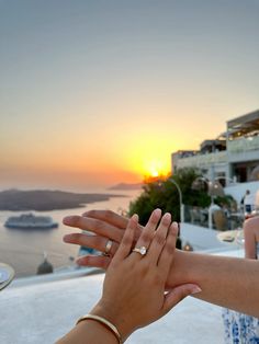 two people reaching out their hands to each other with the sun setting in the background