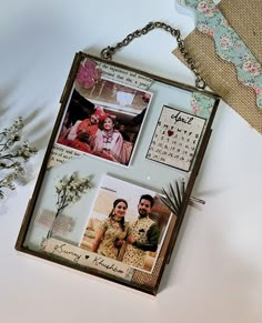 two pictures hanging on a chain next to some flowers